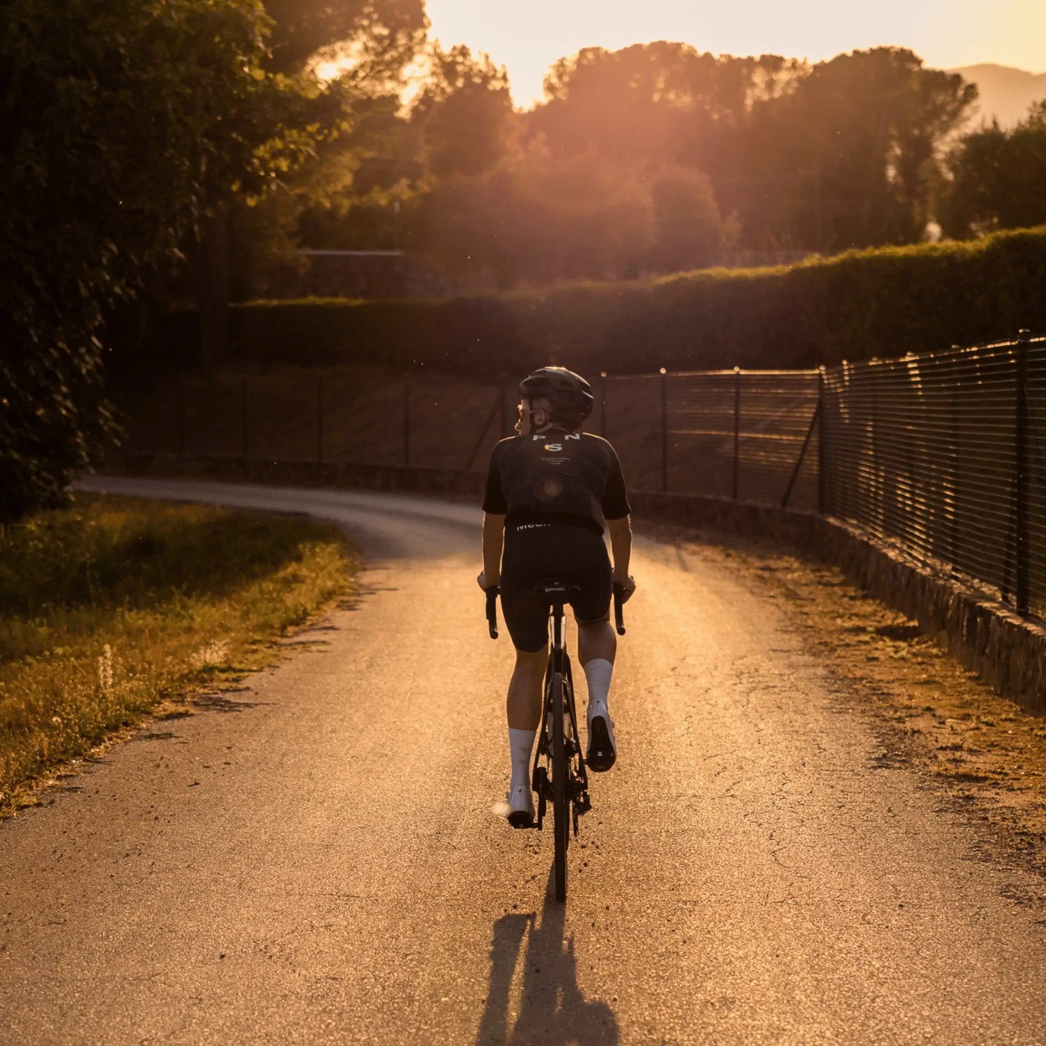 A rider cycling into the sunset in Girona, Spain.