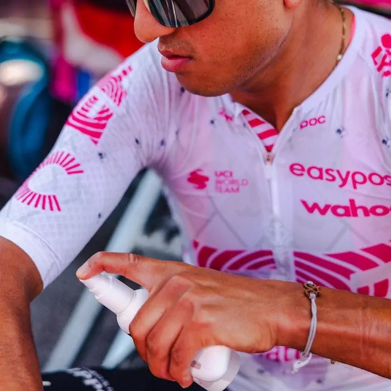 A rider from EF Pro Cycling is applying Pelotan performance sunscreen at the team bus befor a stage of the 2025 Tour of Italy.