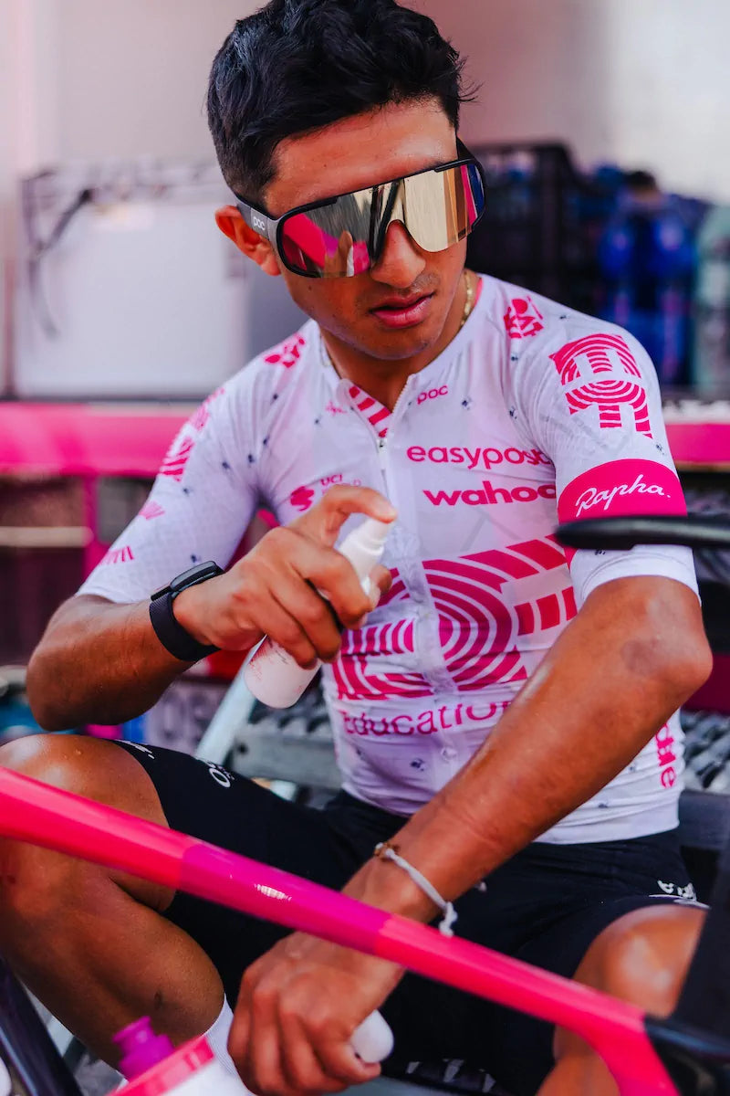 A rider from EF Pro Cycling is applying Pelotan performance sunscreen at the team bus befor a stage of the 2025 Tour of Italy.